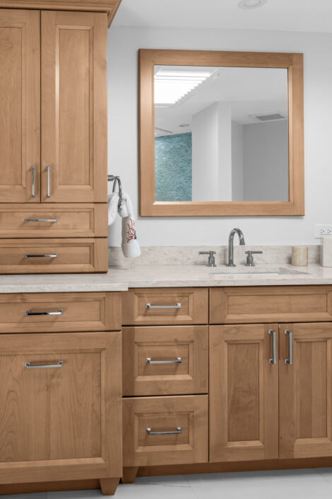 0S3A0138 Bath vanity with natural wood cabinetry, linen tower and framed mirror