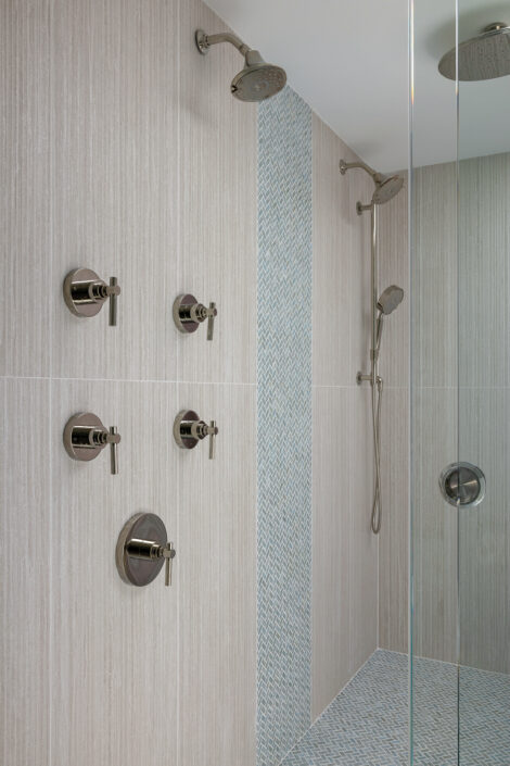 0S3A0144_ Walk-in shower with dual rain showerheads, polished nickel valves and blue herringbone tile accent