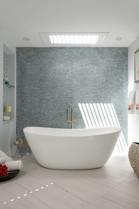 0S3A0160_ Freestanding soaking tub against a blue glass mosaic wall under a skylight