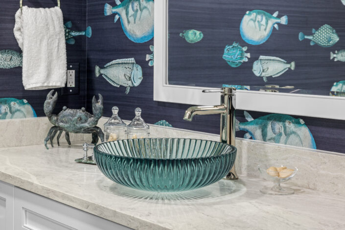 0S3A0546 Aqua glass vessel sink with polished nickel faucet against navy fish wallpaper