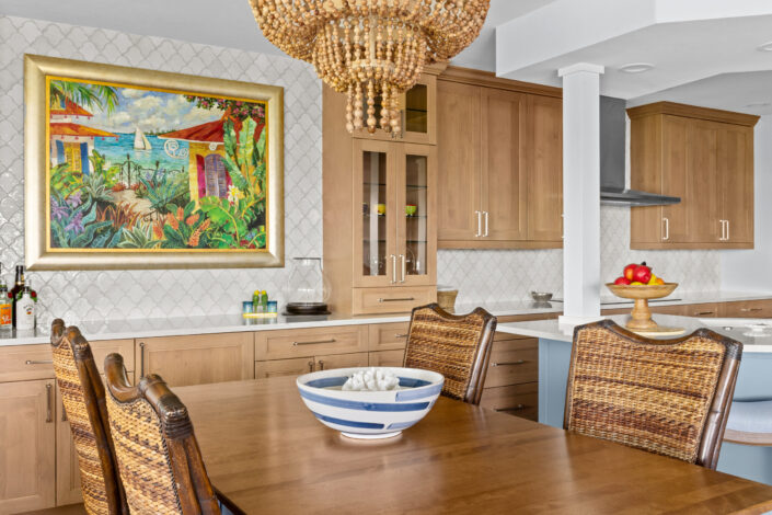 0S3A0662 Dining table with woven chairs, beaded chandelier and colorful artwork over scallop tile