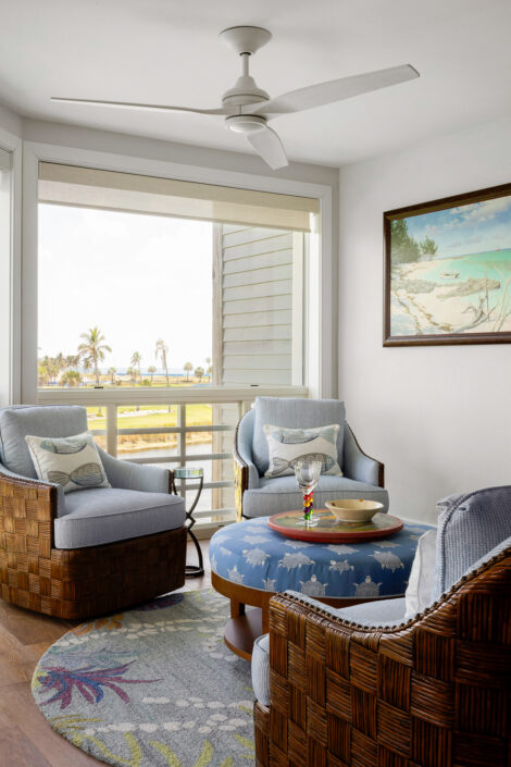 0S3A0708_ Sitting nook with woven chairs and round blue ottoman overlooking the golf course