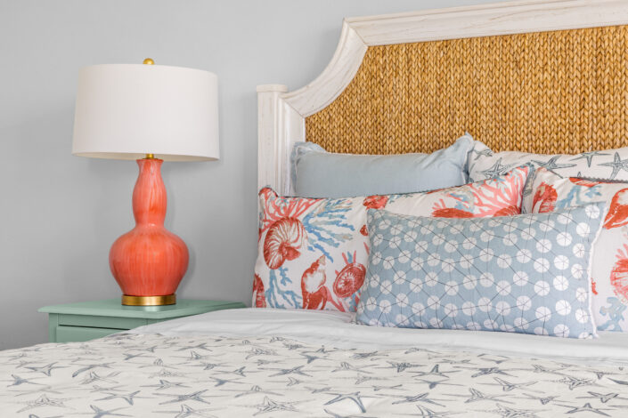 0S3A0793 Seagrass headboard with coral lamp and coral and blue accent pillows
