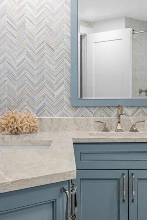 0S3A0822 Guest bath with blue vanity, framed blue mirror and chevron glass tile wall