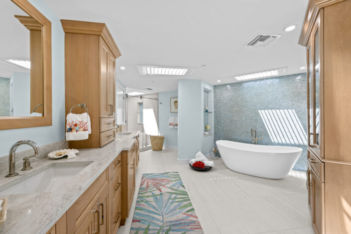 lands-end-penthouse-0S3A0116 Spa-inspired primary bath with wood vanity and freestanding soaking tub