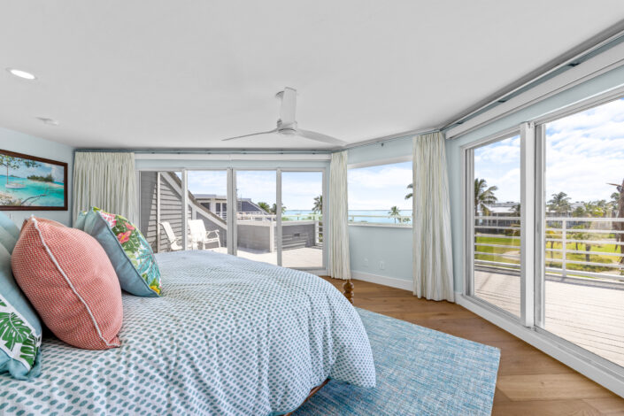 lands-end-penthouse-0S3A0121 Primary bedroom with sliding glass doors to the balcony and waterfront views
