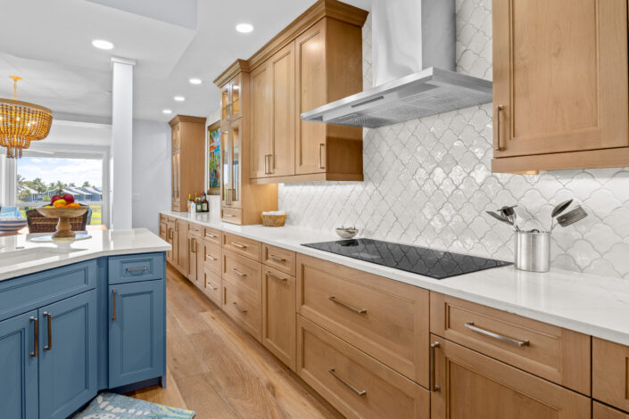 lands-end-penthouse-0S3A0288 Kitchen with white scallop tile backsplash, wood cabinets and stainless range hood