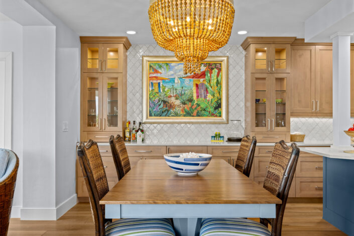 lands-end-penthouse-0S3A0313 Dining area with beaded wood chandelier, colorful island artwork and glass-front cabinets