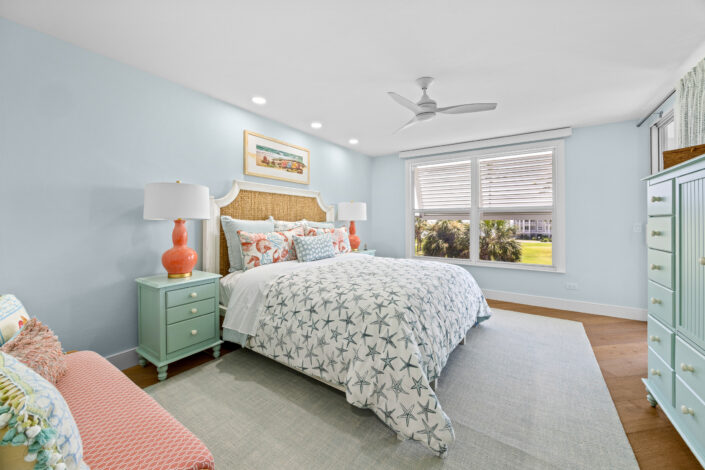 lands-end-penthouse-0S3A0352 Guest bedroom with seagrass headboard, coral lamps and starfish bedding